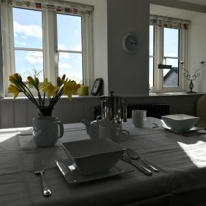 a table with a white table cloth and flowers on it at Uplands Garden in Morecombelake