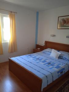1 dormitorio con 1 cama con edredón azul y ventana en Apartment Ana, en Stomorska