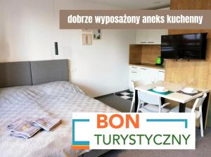 sypialnia z łóżkiem i stołem z telewizorem w obiekcie Villa Alpina - 5 minut do szlaków i wyciągów w Szklarskiej Porębie