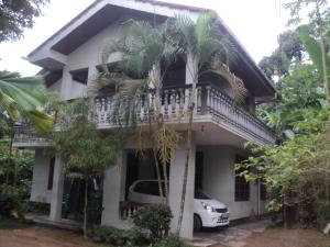 a white house with a car parked in front of it at SUPERFINE Apartment in Galle