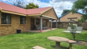 a brick house with a bench in the yard at All Are Welcome Guest House in Brakpan