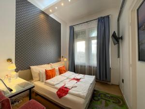 een kleine slaapkamer met een bed en een raam bij Centerpoint Panzio Digital Pansion Heritage Collection in Boedapest
