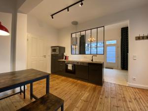 an open kitchen with a table and a table sidx sidx sidx at URBAN STAY Hamburg - Apartments "BACKBORD" & "STEUERBORD mit Sauna" in Hamburg