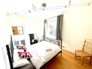 a bedroom with a bed and a chair at Maidenhead - Stylish 4 bedroom apartment in Maidenhead