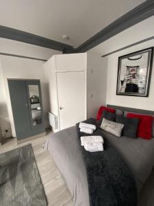 a bedroom with a gray bed with red pillows at Blackpool Abode - 124 Elite Apartments in Blackpool