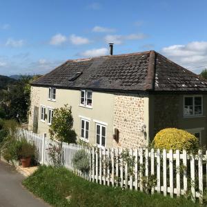 uma casa branca com uma cerca branca em Uplands Garden em Morecombelake