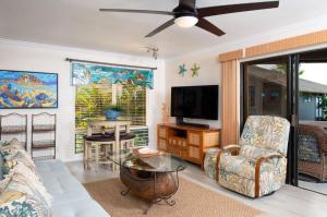 a living room with a couch and a tv at Spacious & Inviting Kanaloa #3503 by Casago Kona - Come Play in Kailua-Kona