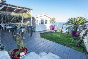 une terrasse en bois avec une table et des chaises dessus dans l'établissement casa dei zitelli studio de charme avec jardin et terrasse, à Brando