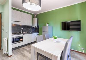 una cucina con tavolo bianco e parete verde di Garden house - con Terrazzo a Grugliasco