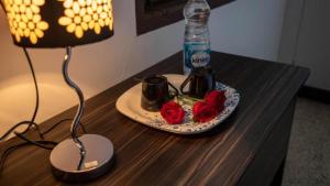 a table with a plate with two roses and a lamp at BlueMoon Homestay in Puducherry