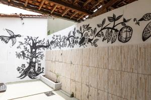 a wall with birds and butterflies painted on it at Vila Barroca Estalagem in São Cristóvão