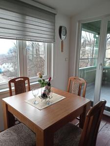 a dining room table with glasses and a vase of flowers at Apartman Jasmin in Vrnjačka Banja