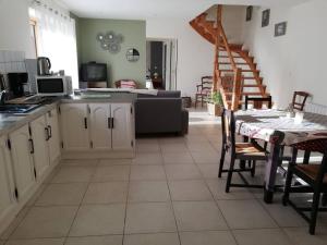 a kitchen and living room with a table and a couch at La maison des chevreuils in Plouigneau +9 photos