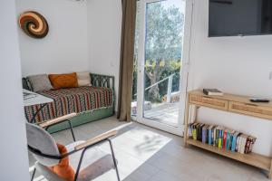 a room with a chair and a couch and a window at Gato Preto de Silves - Adults Only in Silves