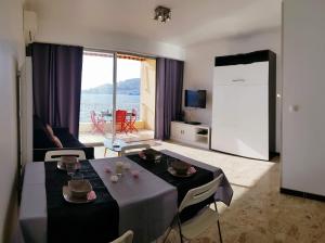 Una sala de estar con una mesa con sillas y una sala de estar en Sudio bord de mer Ajaccio, en Ajaccio