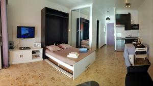 Un dormitorio grande con una cama y una cocina. en Sudio bord de mer Ajaccio, en Ajaccio