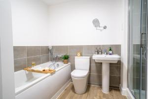 a bathroom with a toilet and a sink and a bath tub at 3 Beds with off-street parking for 2 cars, fast Wifi, sleeps 6 in Ashby de la Zouch +22 photos