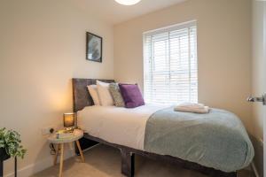 a bedroom with a large bed and a window at 3 Beds with off-street parking for 2 cars, fast Wifi, sleeps 6 in Ashby de la Zouch