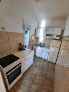 a kitchen with white cabinets and a stove top oven at Apartman Marina in Selce