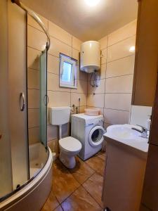 La salle de bains est pourvue d'un lavabo et d'un lave-linge. dans l'établissement Apartman Marina, à Selce