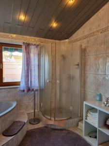 uma casa de banho com um chuveiro, uma banheira e um lavatório. em Burgauer Hof em Burgau