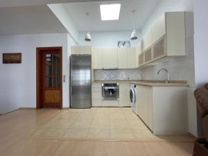 a kitchen with white cabinets and a sink and a dishwasher at Casa Brisa del Este in Mala
