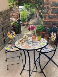un tavolo da patio con due sedie e un tavolo con fiori di Casa Vacanza Cleo a Catania