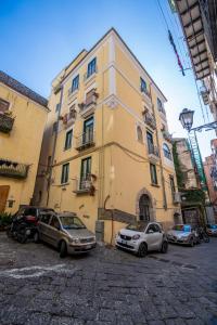 a yellow building with cars parked in front of it at Terre Dipinte in Salerno