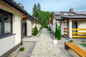 a cobblestone alley between two buildings with a bench at Domki letniskowe - SEVEN in Dąbki