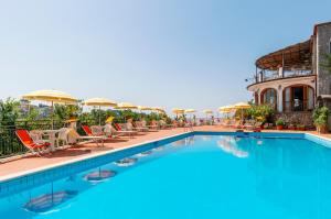 une grande piscine avec des chaises et des parasols dans l'établissement Albergo La Margherita, à Scala