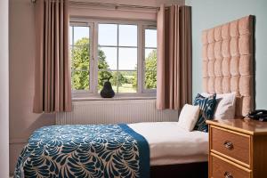 sypialnia z łóżkiem i oknem w obiekcie The Garden Suite at Shuttleworth w mieście Old Warden