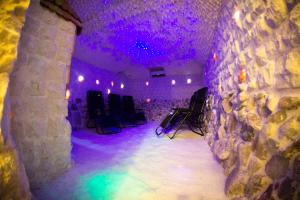 Zimmer mit einer Steinmauer und violetten Lichtern in der Unterkunft Ośrodek nad jeziorem - Radew Rosnowo in Rosnowo