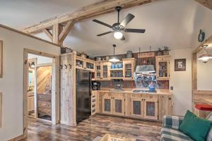 een keuken met houten kasten en een plafondventilator bij Kerrville Converted Barn Tiny Home with Kayaks! in Kerrville
