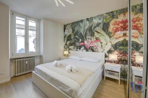 a bedroom with a large white bed with towels on it at Apa Dom Downtown Family Apartment DesenzanoLoft Official Partner Homes & Villas by Marriott Bonvoy in Desenzano del Garda