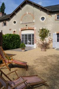 two lawn chairs sitting in front of a house at Au calme dans la campagne du Haut Anjou in Pouancé