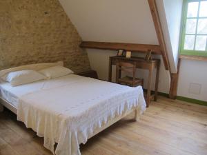 ein Schlafzimmer mit einem weißen Bett und einem Tisch in der Unterkunft poppy chambres d'hotes in Tursac