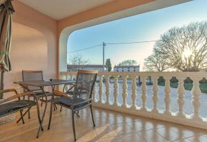 een balkon met een tafel en stoelen en een hek bij Koraca B4 in Krmenjak