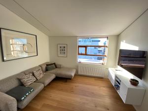 ein Wohnzimmer mit einem Sofa und einem TV in der Unterkunft Reykjavík Central Apartments in Reykjavík