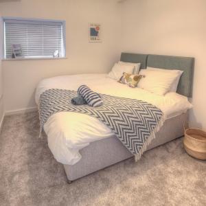 um quarto com uma cama grande e uma cabeceira verde em The Swell, Rhosneigr - Ground floor 2 bed With Parking em Rhosneigr