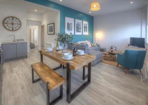 a living room with a table and a couch at The Swell, Rhosneigr - Ground floor 2 bed With Parking in Rhosneigr
