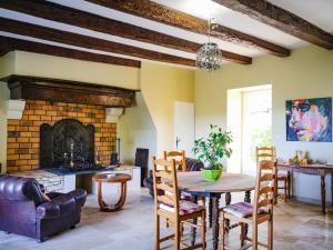 uma sala de estar com uma mesa e uma lareira em L'Antre des Bastides em Saint-Martin-de-Villeréal