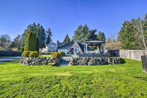 a house with a stone wall and a gazebo at Puget Sound Cabin with Hot Tub and Water Views! in Bremerton