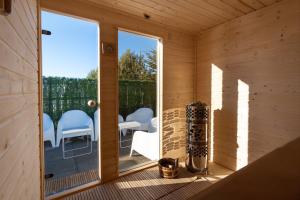 a wooden room with a balcony with white chairs at Serenity in Pribylina