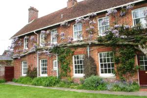 a red brick house with flowers on it at Bridge Farmhouse in Salisbury