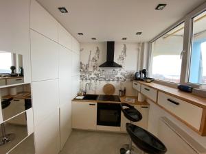 a kitchen with white cabinets and a stove top oven at Apartament B122 z widokiem na morze in Gdańsk