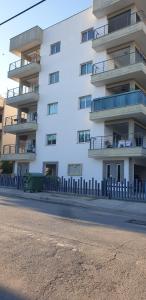 un grand bâtiment blanc avec une clôture devant lui dans l'établissement SUPERLA LUXURY APARTMENT (BREAKBOOKING-CY), à Limassol