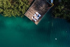 zwei Personen stehen auf einem hölzernen Steg im Wasser in der Unterkunft Panoramic Hotel San Carlo Ledro in Ledro