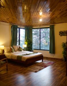 a bedroom with a large bed in a room with windows at Umda Hotel Montana in Ayubia