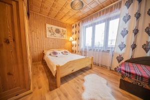 a small bedroom with a bed and a window at Apartamenty Małgorzatka in Zakopane