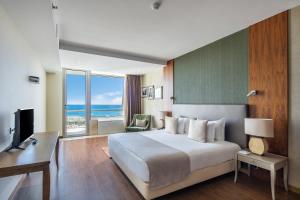 Habitación de hotel con cama grande y escritorio. en Angra Marina Hotel, en Angra do Heroísmo
